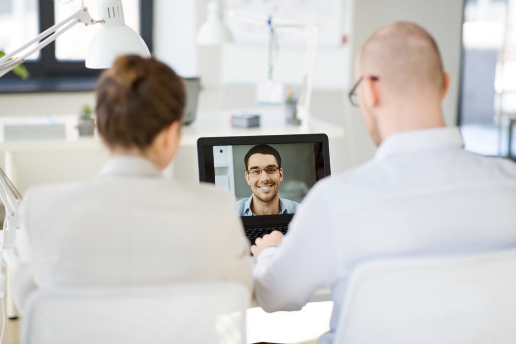Business people in video call with person smiling.
